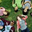 multiple students laying in the grass in the park blocks