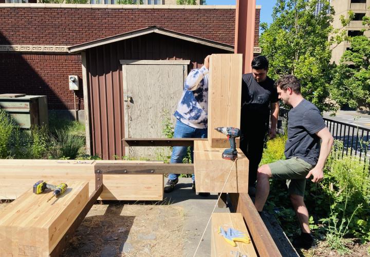 Students building benches for campus patio