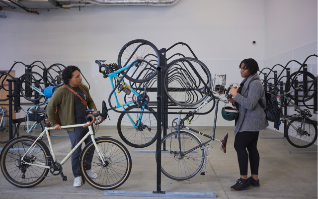 Image of two students in the bike garage preparing to unlock their bikes.