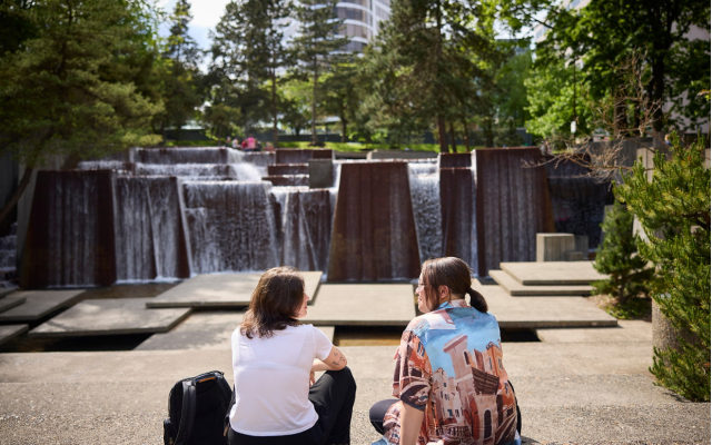 Image of two students sitting in front of fountain at Keller Park