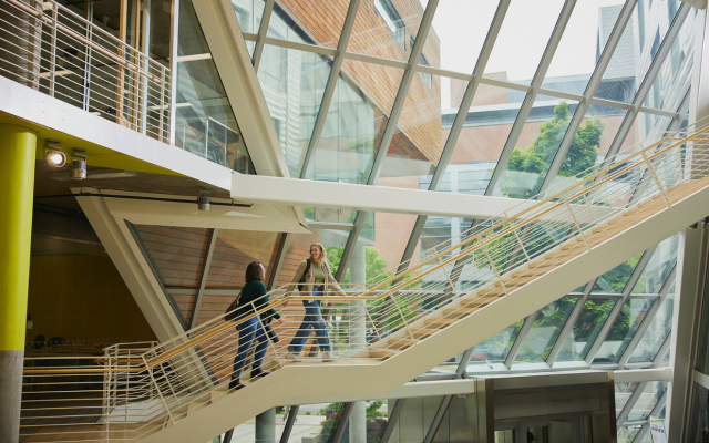 Image of two students walking up the staircase in the KMC business biuilding 