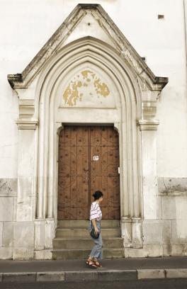 Student standing in front of large doors in France