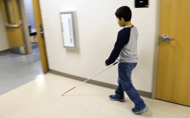 Child walking with a white cane