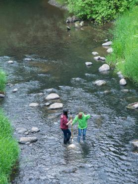 Two women standing in the middle of Johnson Creek
