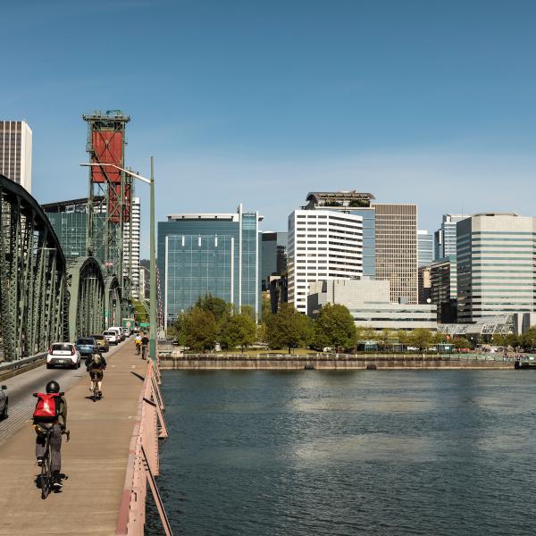 Cyclists ride on bridge toward downtown Portland.