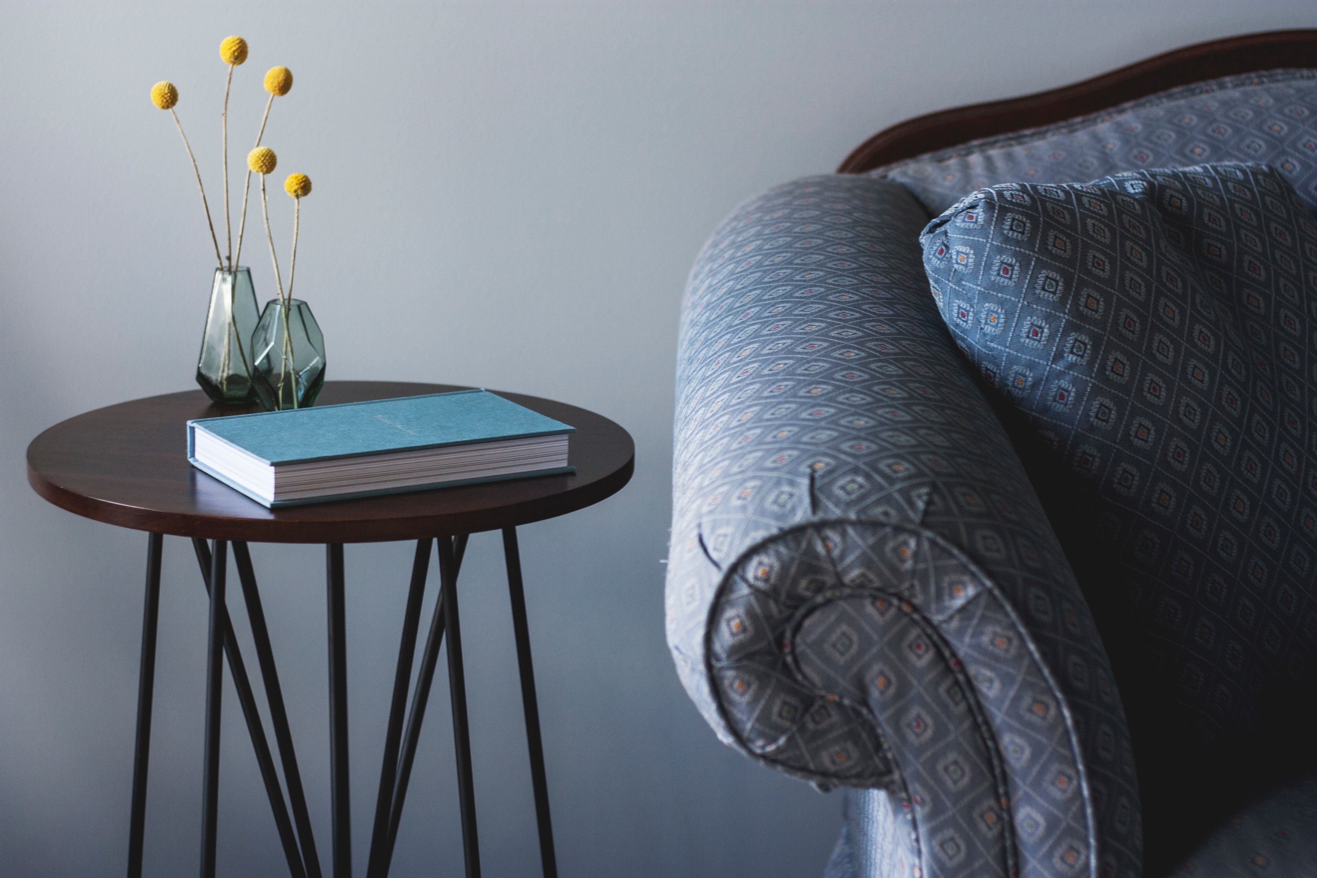 This photo is decorative. A blue chair and side table with a notebook.
