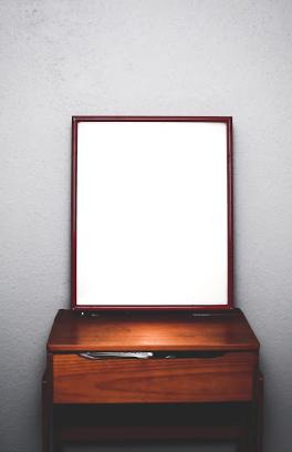 Empty desk with a mirror above it.