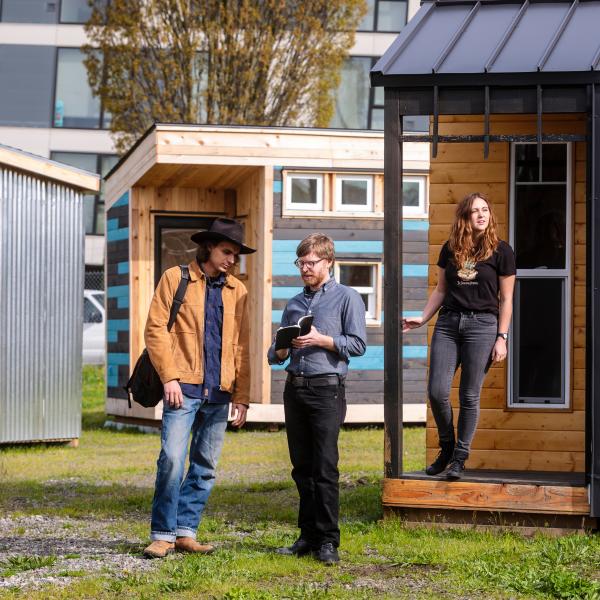 PSU faculty and students in front of tiny homes for people experiencing homelessness