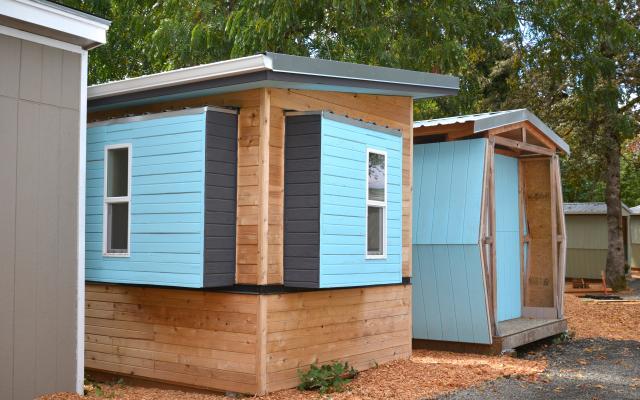 photo of wooden shelters with blue accent painting