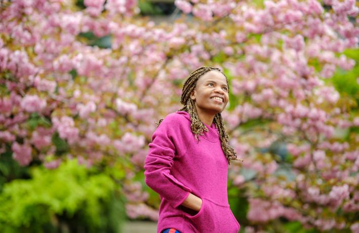 Student in front of cherry blossom trees