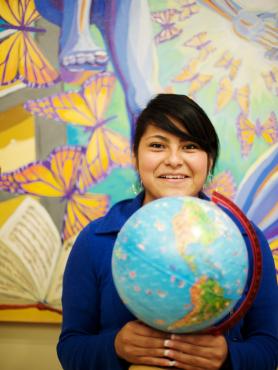 Woman holding world globe in classroom