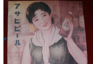public domain photo of old Asahi Beer poster depicting a Japanese woman smiling and holding up a bottle of beer.