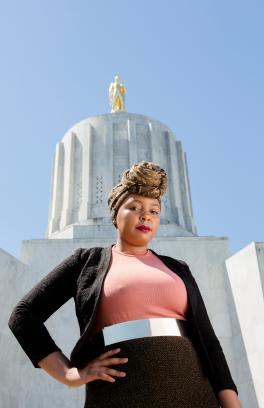 Photo of a black woman standing in front of the Oregon state capital looking like a boss.