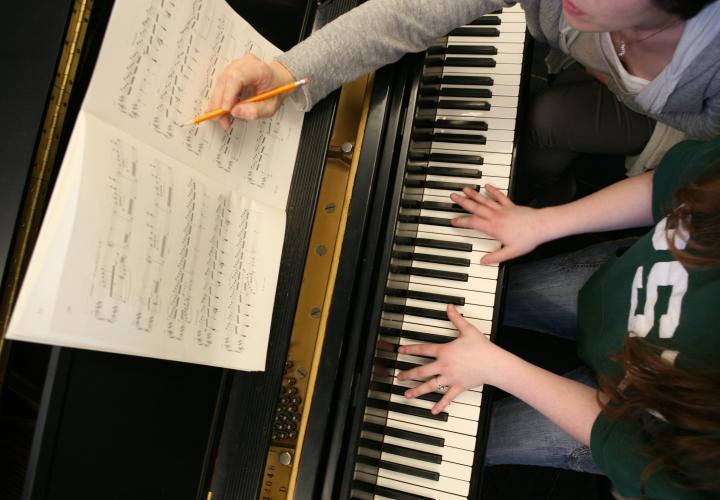 Instructor and student edit a score at the piano