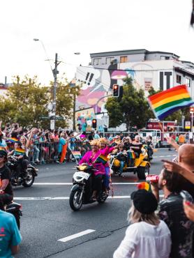 image of a sunny pride parade and dykes on bikes rides down the street