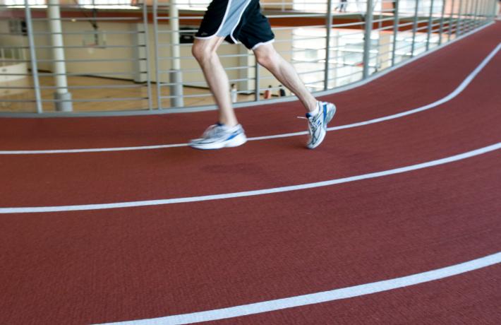 Person running around the indoor track