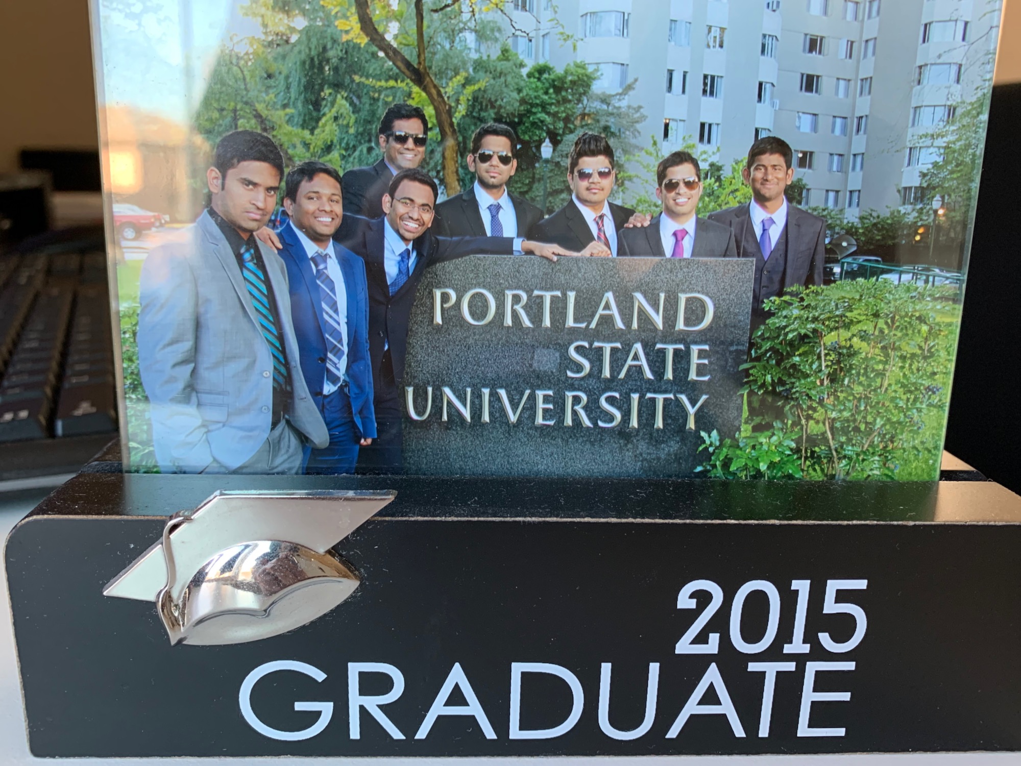 There is a photo frame with a picture of graduates.