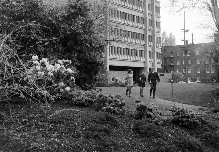 Black and white photo of students walking through campus in the 1950s