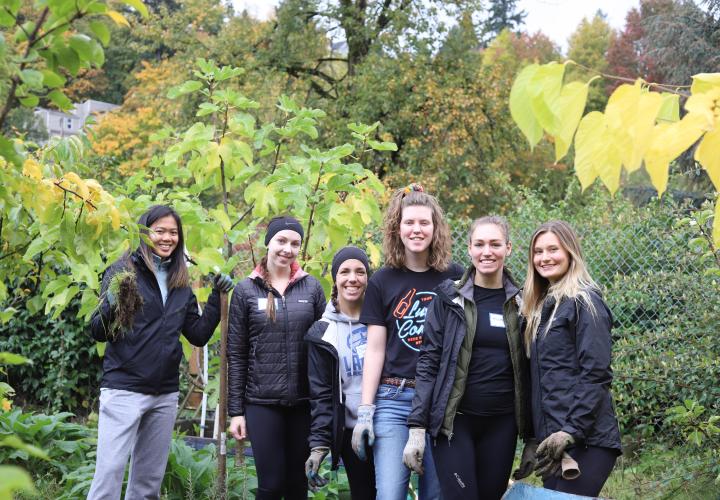 Student volunteers on a Serve Your Campus project pose wearing gloves at the PSU Orchard