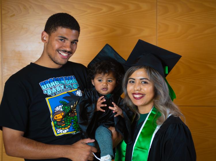 A PSU graduate with her child and partner.