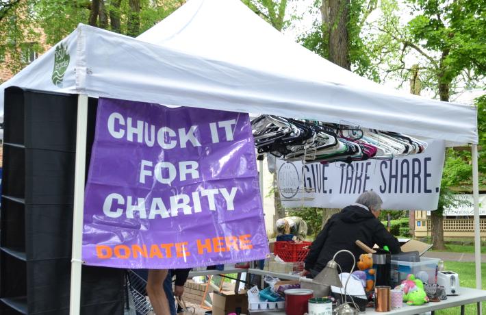 Tent with donated items and sign saying chuck it for charity donate here