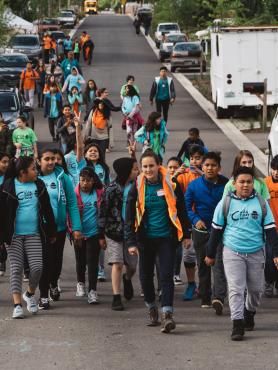 A group of children in Portland's Cully neighborhood walk towards the camera