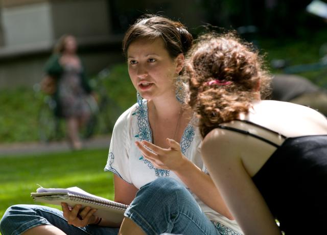two students engaged in conversation outside in the PSU Park Blocks