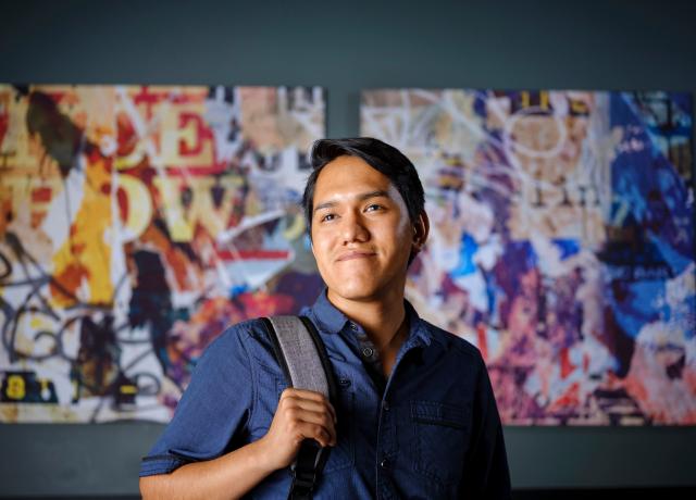 Luis Balderas Villagrana, a “Dreamer”, standing in front of a mural