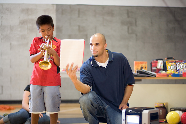 Student with child playing an instrument. 
