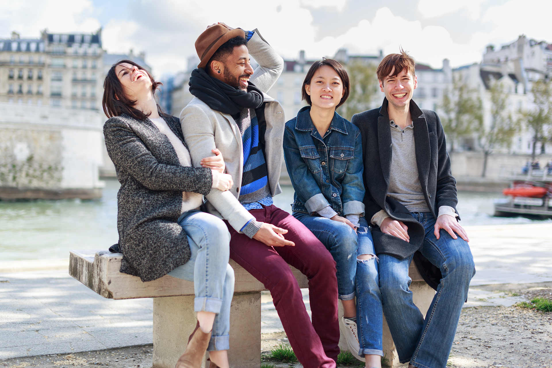 Four students having fun on the Seine in Paris