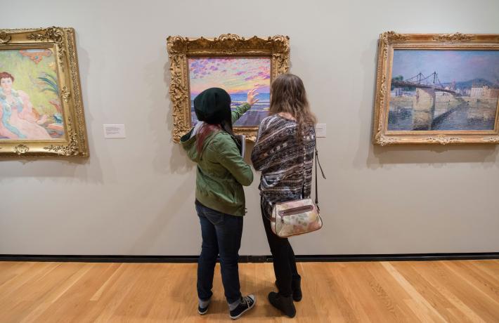Students looking at a painting in an art museum