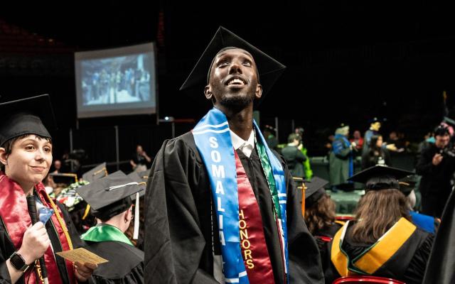 A student looks hopeful and excited at graduation. 