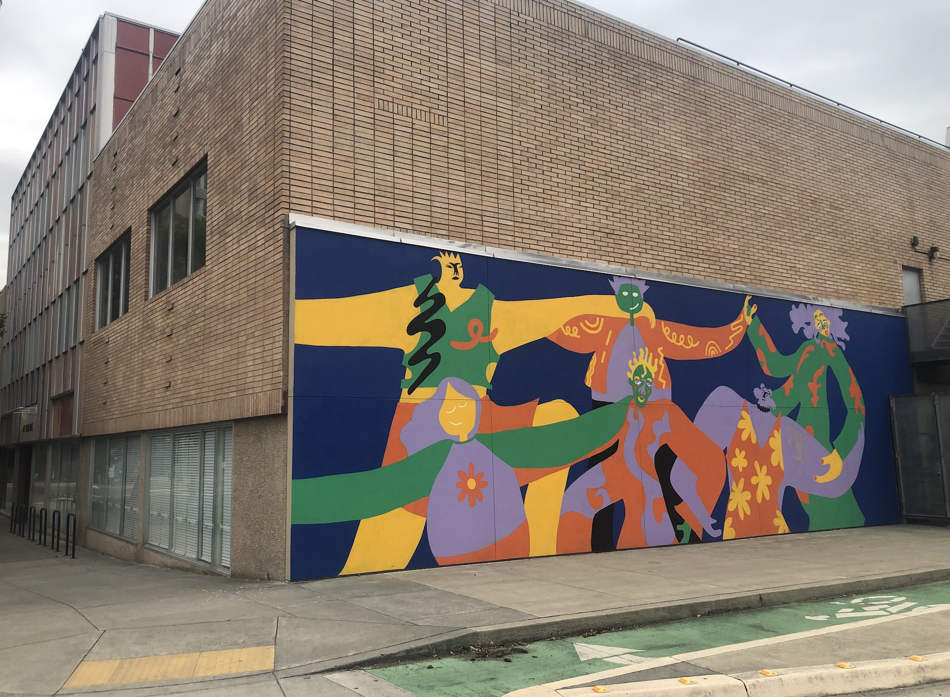 Colorful mural with fanciful figures painted on the south wall of the Art Building