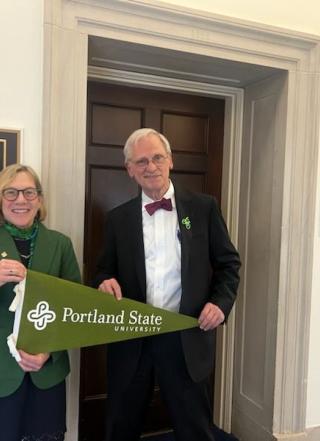 PSU president ann cudd and congressman earl blumenauer hold a portland state flag