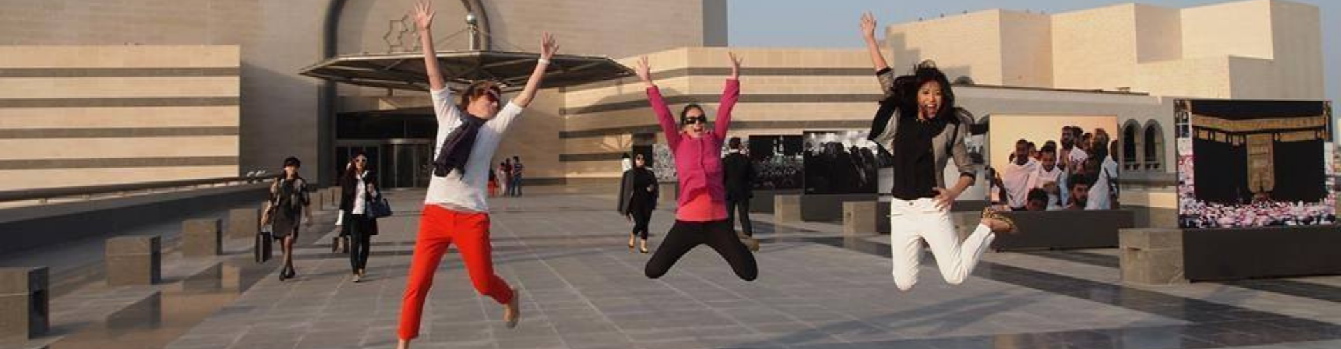students leaping in front of building