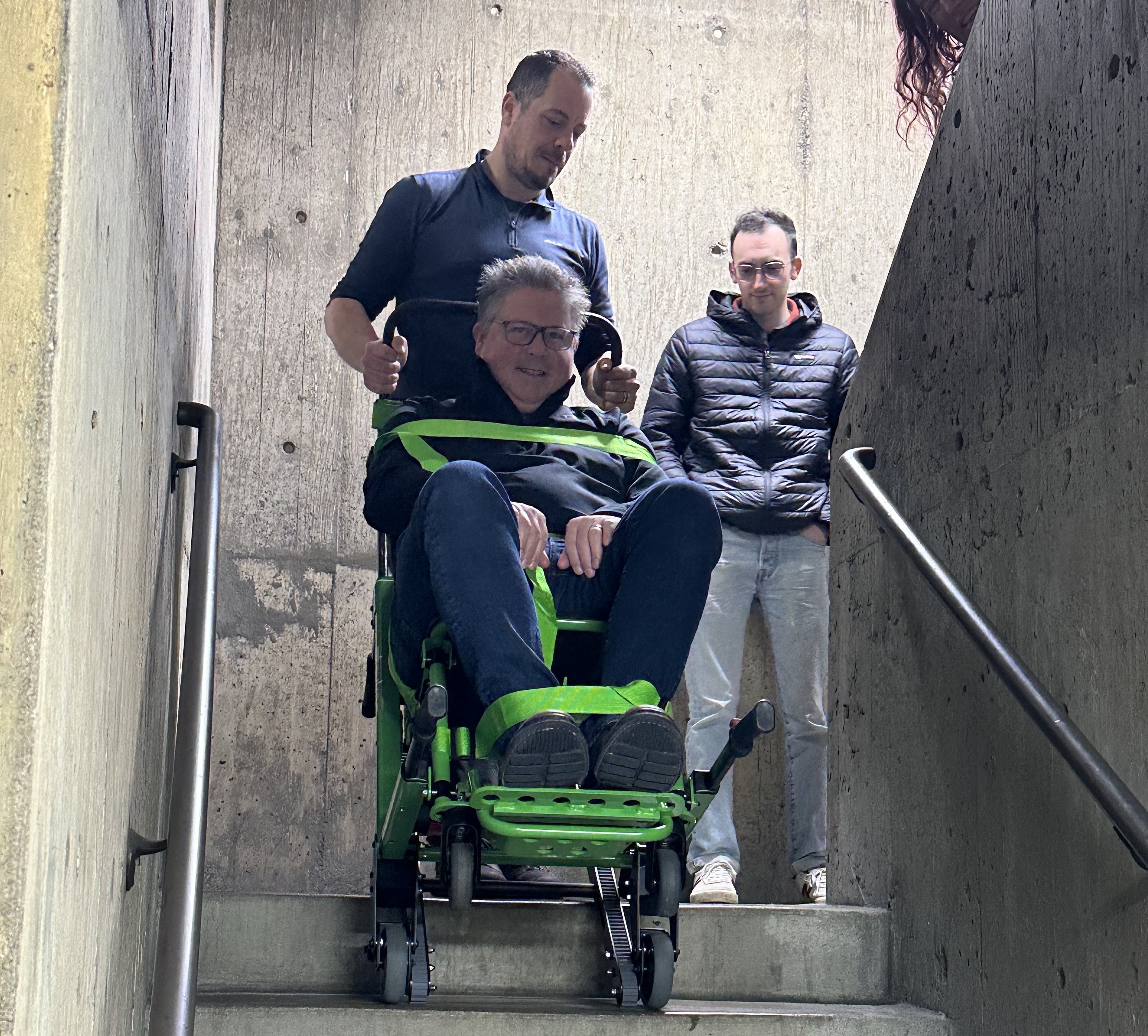 Man in Stryker evacuation chair being lifted down stairs
