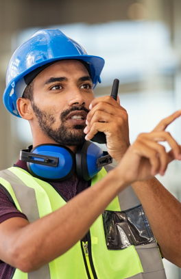 Man in construction safety gear with a walkie-talkie