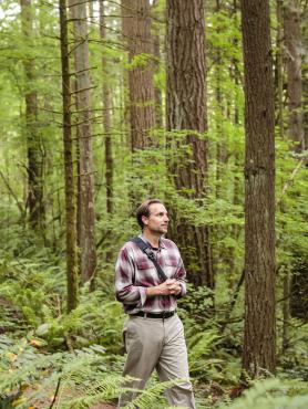 Portland State University environmental science and management graduate student walking in the forest.