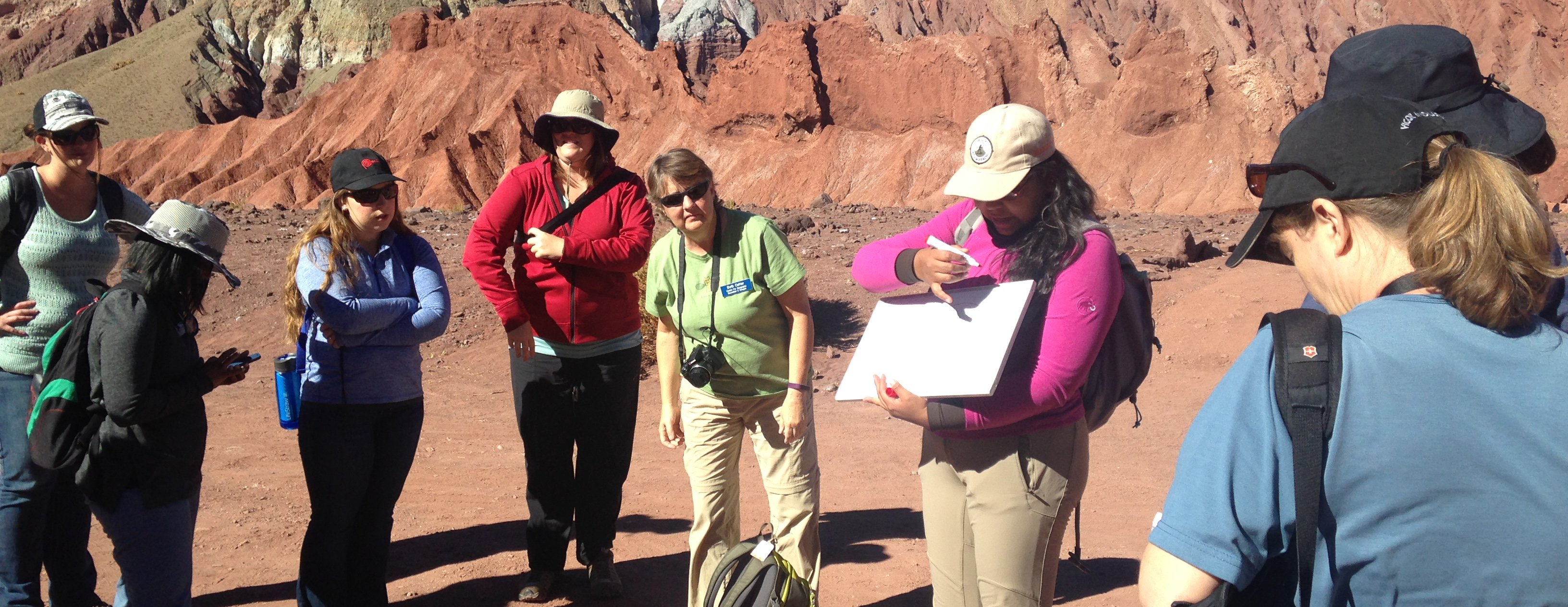 C-GEO Teacher Consultants in Chile listening to a guide, desert mountain backdrop