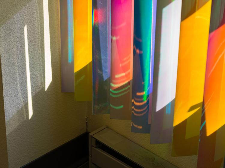 Close-up of the reflective blinds in the corner of the room, looking down toward the floor