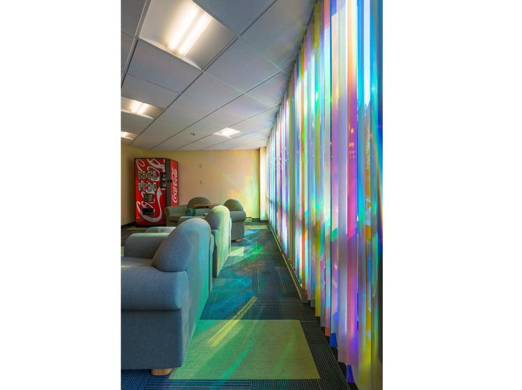 The colorful reflective blinds are seen at an extreme angle, from close to the window
