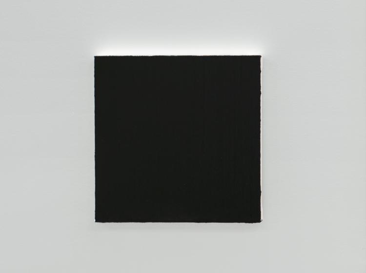 Close-up of the small, square black painting, against a white wall