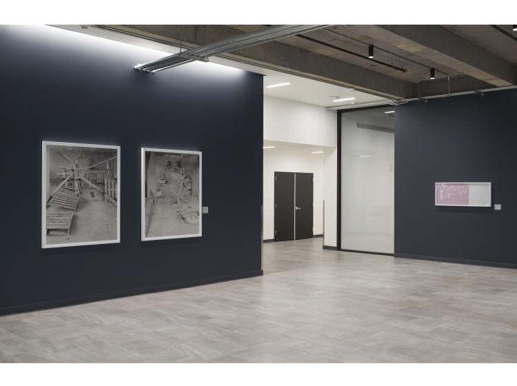 The two framed photos are shown hung side-by-side on a dark grey wall, viewed from an angle