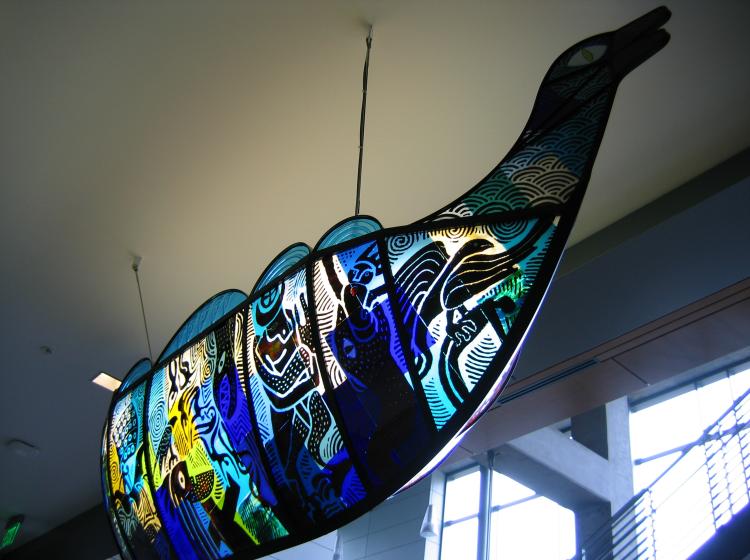 Sculpture of a Viking ship, in iron and colored glass, suspended from ceiling in the ASRC lobby. This side of the sculpture has blue, white, teal and yellow glass