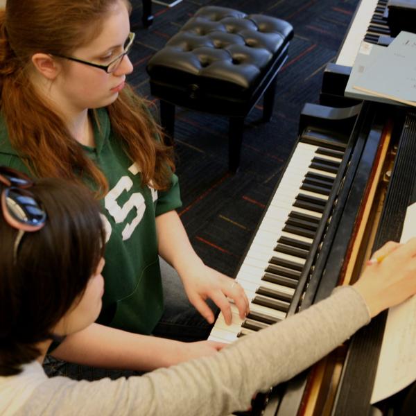 Piano student and teacher in private lesson
