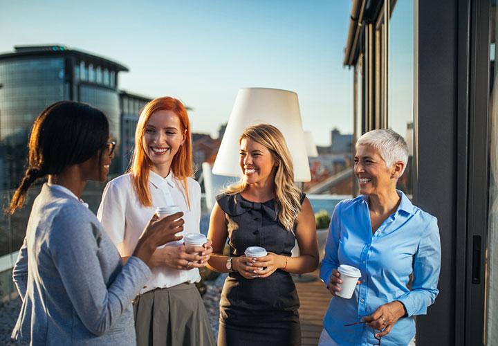 Smiling group of women drinking coffee and talking