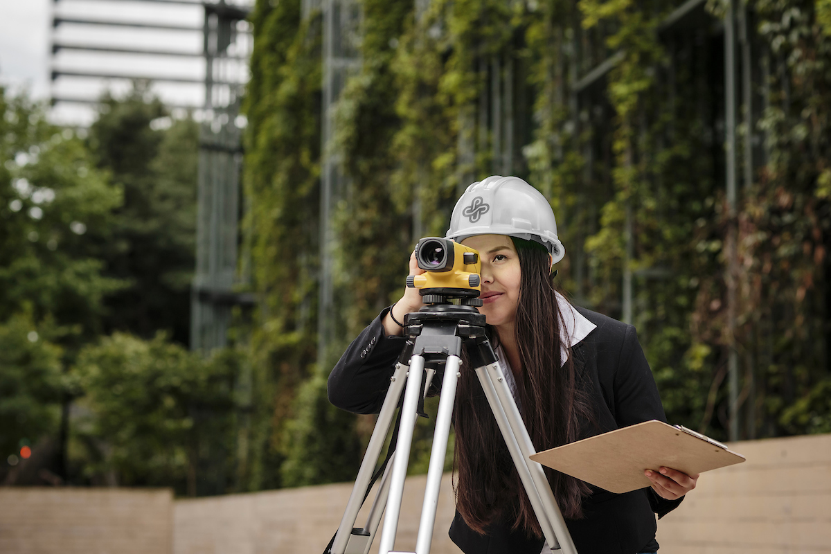 Girl Looking through Surveyor (Foliage in Background)