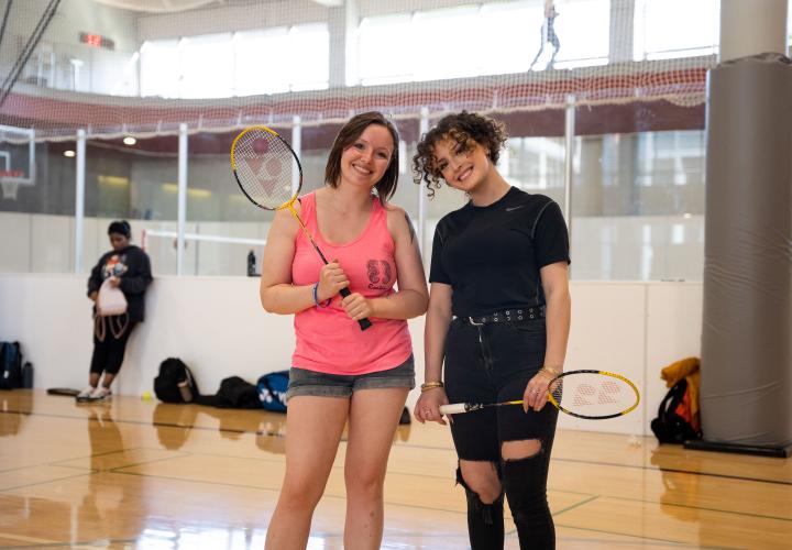 2 people posing with badminton rackets