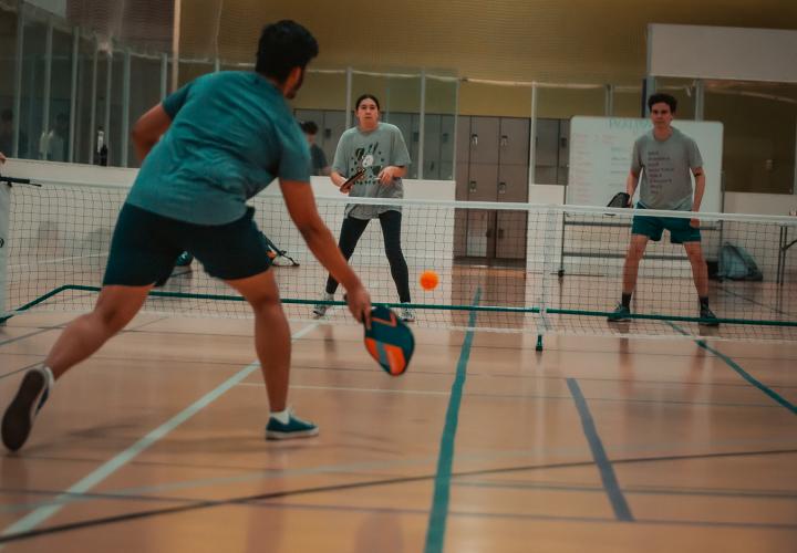 3 people playing pickleball