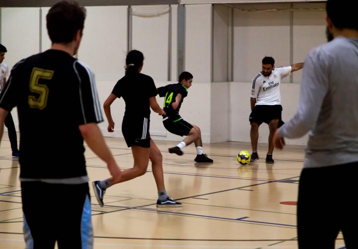 5 people playing indoor soccer